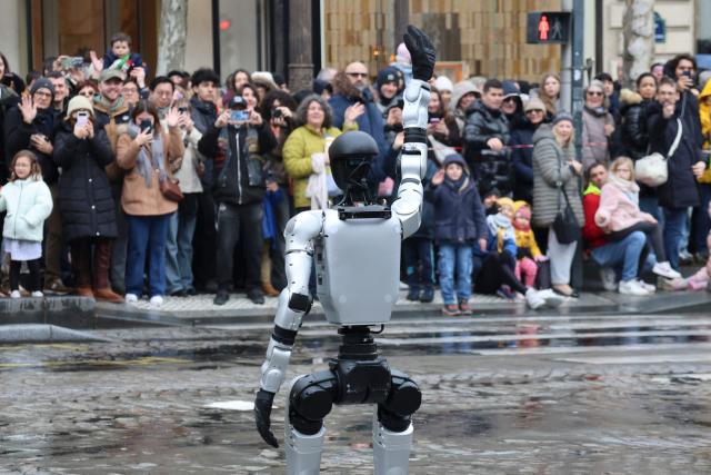 (260202) -- PARIS, Feb. 2, 2026 (Xinhua) -- A humanoid robot, invented by a Chinese company and supplied by French technology firm INNOV8 Group, waves during a parade celebrating the upcoming Chinese New Year on the Champs-Elysees avenue in Paris, France, Feb. 1, 2026. (Xinhua/Zhang Baihui)
