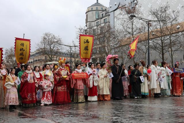 (260202) -- PARIS, Feb. 2, 2026 (Xinhua) -- People in Chinese traditional attires perform during a parade celebrating the upcoming Chinese New Year on the Champs-Elysees avenue in Paris, France, Feb. 1, 2026. (Xinhua/Zhang Baihui)
