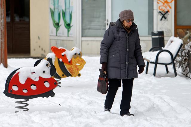 (260202) -- BUCHAREST, Feb. 2, 2026 (Xinhua) -- A woman walks through a snow-covered playground in Bucharest, Romania, on Feb. 2, 2026. Romania's National Meteorological Administration (ANM) on Monday issued a Code Yellow warning for severe cold and frost, affecting more than half of the country, from Monday morning until Tuesday. (Photo by Cristian Cristel/Xinhua)