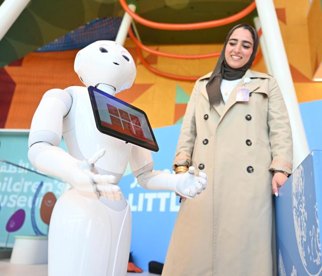 (260202) -- HAWALLI GOVERNORATE, Feb. 2, 2026 (Xinhua) -- A student stands next to a robot during the exhibition in Hawalli Governorate, Kuwait, Feb. 2, 2026. An one-day educational technology exhibition was held on Monday, highlighting Kuwait's commitment to advancing education by promoting innovation, digital transformation, and the effective integration of technology into teaching and learning. (Photo by Asad/Xinhua)
