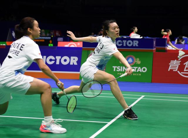 (260203) -- QINGDAO, Feb. 3, 2026 (Xinhua) -- Xiao En Heng/Jin Yu Jia (R) of Singapore compete in the women's doubles match against Kim Hye Jeong/Kong Hee Yong of South Korea during the Group Z match between Singapore and South Korea at Badminton Asia Team Championships 2026 in Qingdao, east China's Shandong Province, Feb. 3, 2026. (Xinhua/Li Ziheng)