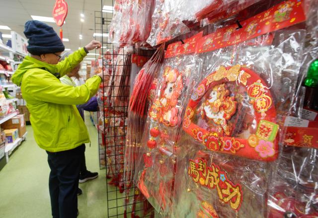 (260203) -- VANCOUVER, Feb. 3, 2026 (Xinhua) -- A man selects festive decorations at a Chinese supermarket ahead of the upcoming Chinese New Year of the Horse in Vancouver, Canada, on Feb. 2, 2026. (Photo by Liang Sen/Xinhua)