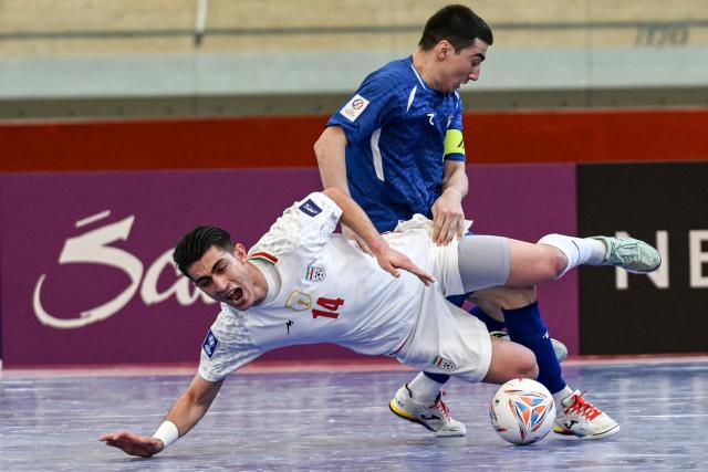 (260203) -- JAKARTA, Feb. 3, 2026 (Xinhua) -- Behrooz Azimihematabadi (L) of Iran vies with Ilkhomjon Khamroev of Uzbekistan during the quarterfinal match between Iran and Uzbekistan at the AFC Futsal Asian Cup 2026 in Jakarta, Indonesia, Feb. 3, 2026. (Xinhua/Agung Kuncahya B.)