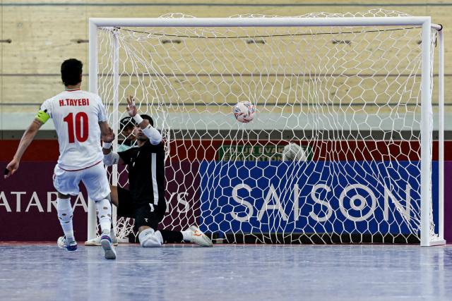 (260203) -- JAKARTA, Feb. 3, 2026 (Xinhua) -- Hossein Tayebibidgoli (L) of Iran shoots a penalty kick during the quarterfinal match between Iran and Uzbekistan at the AFC Futsal Asian Cup 2026 in Jakarta, Indonesia, Feb. 3, 2026. (Xinhua/Agung Kuncahya B.)