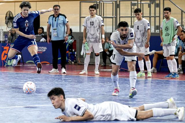 (260203) -- JAKARTA, Feb. 3, 2026 (Xinhua) -- Yamanaka Shoto (L) of Japan shoots the ball during the quarterfinal match between Japan and Afghanistan at the AFC Futsal Asian Cup 2026 in Jakarta, Indonesia, Feb. 3, 2026. (Xinhua/Agung Kuncahya B.)
