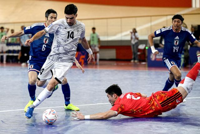 (260203) -- JAKARTA, Feb. 3, 2026 (Xinhua) -- Sayed Mojtaba Husseini (2nd L) of Afghanistan vies with Tabuchi Hiroshi (bottom), goalkeeper of Japan during the quarterfinal match between Japan and Afghanistan at the AFC Futsal Asian Cup 2026 in Jakarta, Indonesia, Feb. 3, 2026. (Xinhua/Agung Kuncahya B.)
