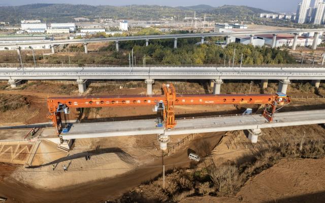 (260203) -- KUNMING, Feb. 3, 2026 (Xinhua) -- An aerial drone photo shows staff members working to position the last box girder of a bridge along the Chongqing-Kunming high-speed railway in Chenggong District of Kunming, southwest China's Yunnan Province, Feb. 3, 2026. As the last box girder of a bridge was precisely positioned on Tuesday, the construction of bridges along the Chongqing-Kunming High-Speed Railway was fully completed, paving way for subsequent construction work.
   When the Chongqing-Kunming high-speed railway opens to traffic, travel time between Chongqing and Kunming will be significantly reduced. This will boost connectivity between China's southwest region and the rest of the country, and promote coordinated regional economic development. (Xinhua/Chen Xinbo)