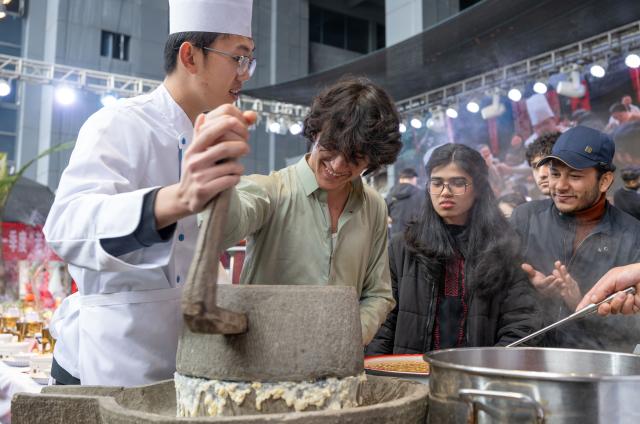 (260203) -- CHONGQING, Feb. 3, 2026 (Xinhua) -- Foreign students experience traditional soy milk making during an event held in Banan District of Chongqing Municipality, southwest China, Feb. 3, 2026. As the Spring Festival approaches, Banan District of Chongqing Municipality hosted a "Laowai@Chongqing" event. "Laowai" is a Chinese slang term meaning "foreigners".
   Twenty international students gathered to engage in an immersive experience of local traditional cultural practices such as Mudong folk songs, paper cutting, and glutinous rice cake making, embracing the festive atmosphere of the Chinese New Year, which falls on Feb. 17 this year. (Xinhua/Chen Cheng)