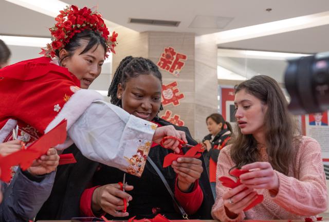 (260203) -- CHONGQING, Feb. 3, 2026 (Xinhua) -- Foreign students experience paper cutting under the instruction of a teacher during an event held in Banan District of Chongqing Municipality, southwest China, Feb. 3, 2026. As the Spring Festival approaches, Banan District of Chongqing Municipality hosted a "Laowai@Chongqing" event. "Laowai" is a Chinese slang term meaning "foreigners".
   Twenty international students gathered to engage in an immersive experience of local traditional cultural practices such as Mudong folk songs, paper cutting, and glutinous rice cake making, embracing the festive atmosphere of the Chinese New Year, which falls on Feb. 17 this year. (Xinhua/Chen Cheng)