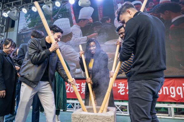 (260203) -- CHONGQING, Feb. 3, 2026 (Xinhua) -- Foreign students experience glutinous rice cake making during an event held in Banan District of Chongqing Municipality, southwest China, Feb. 3, 2026. As the Spring Festival approaches, Banan District of Chongqing Municipality hosted a "Laowai@Chongqing" event. "Laowai" is a Chinese slang term meaning "foreigners".
   Twenty international students gathered to engage in an immersive experience of local traditional cultural practices such as Mudong folk songs, paper cutting, and glutinous rice cake making, embracing the festive atmosphere of the Chinese New Year, which falls on Feb. 17 this year. (Xinhua/Chen Cheng)