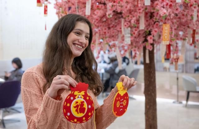 (260203) -- CHONGQING, Feb. 3, 2026 (Xinhua) -- An Algerian student displays a lucky bag made during an event held in Banan District of Chongqing Municipality, southwest China, Feb. 3, 2026. As the Spring Festival approaches, Banan District of Chongqing Municipality hosted a "Laowai@Chongqing" event. "Laowai" is a Chinese slang term meaning "foreigners".
   Twenty international students gathered to engage in an immersive experience of local traditional cultural practices such as Mudong folk songs, paper cutting, and glutinous rice cake making, embracing the festive atmosphere of the Chinese New Year, which falls on Feb. 17 this year. (Xinhua/Chen Cheng)