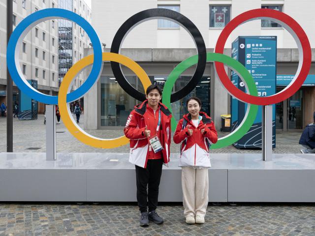 (260203) -- MILAN, Feb. 3, 2026 (Xinhua) -- Chinese figure skating athletes Sui Wenjing (R) and Han Cong pose for photos in front of the Olympic rings at the Olympic Village ahead of the 2026 Milan-Cortina Winter Olympics in Milan, Italy, Feb. 3, 2026. (Xinhua/Zhang Haofu)