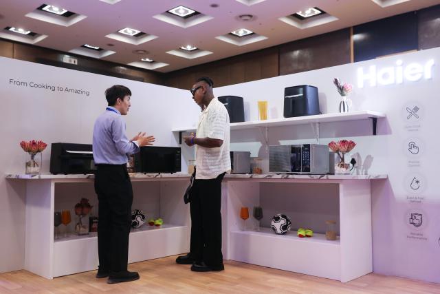 (260203) -- JOHANNESBURG, Feb. 3, 2026 (Xinhua) -- A man asks about products at Haier's launching event in Johannesburg, South Africa, Feb. 2, 2026. China's home appliance giant Haier on Monday held a launch ceremony in Johannesburg, South Africa's economic hub, marking its official entry into the South African market. (Xinhua/Chen Wei)