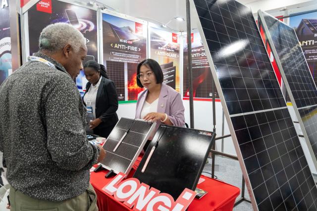 (260203) -- NAIROBI, Feb. 3, 2026 (Xinhua) -- A visitor learns about products at the booth of LONGi Solar Co., Ltd. during the Intersolar Africa 2026 in Nairobi, Kenya, Feb. 3, 2026. TO GO WITH "Africa solar expo opens in Kenya to advance green transition" (Xinhua/Xie Jianfei)