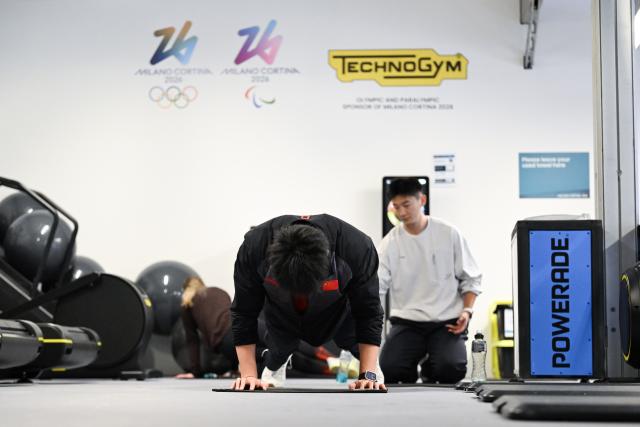 (260203) -- CORTINA D'AMPEZZO, Feb. 3, 2026 (Xinhua) -- Chinese athlete Li Chunjian (front) exercises in the gym at the Cortina D'Ampezzo Olympic & Paralympic Village ahead of the 2026 Milan-Cortina Winter Olympics in Cortina D'Ampezzo, Italy, Feb. 3, 2026. (Xinhua/Lian Yi)