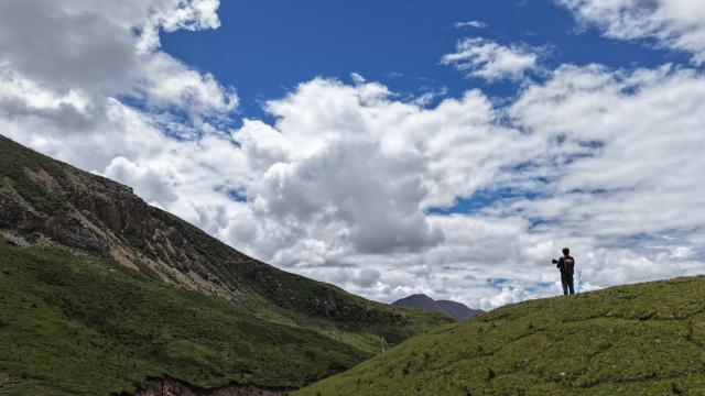 (260203) -- YUSHU, Feb. 3, 2026 (Xinhua) -- A drone photo taken on Aug. 9, 2025 shows Tseten taking photos during his patrol in Angsai Township of Zaduo County, Yushu Tibetan Autonomous Prefecture, northwest China's Qinghai Province. Amid snow-capped mountains and deep valleys in Angsai Township of Zaduo County, an area in Sanjiangyuan National Park, Tseten and Kunga trek over ridges, cross alpine meadows and carry out ecological patrols, pressing the shutter as they move through the landscape.    
   In 2016, Tseten and Kunga became rangers under a public welfare program. Having taught themselves photography, they have been documenting the mountains, rivers and wildlife of their homeland with their cameras while patrolling, collecting litter, monitoring water sources and observing vegetation. 
   Over a decade, their footprints have spread across the grasslands and river shores. Their lens have remained fixed on the changes unfolding on this land: wildlife populations are increasing, traces of garbage on the grasslands have largely disappeared, and the ecological landscape along the Lancang River has grown better and better. (Xinhua/Qi Zhiyue)