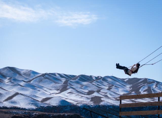 (260204) -- BEIJING, Feb. 4, 2026 (Xinhua) -- This drone photo taken on Feb. 1, 2026 shows a girl playing on a swing on the edge of a canyon in Almaty Region, Kazakhstan. (Xinhua/Li Renzi)