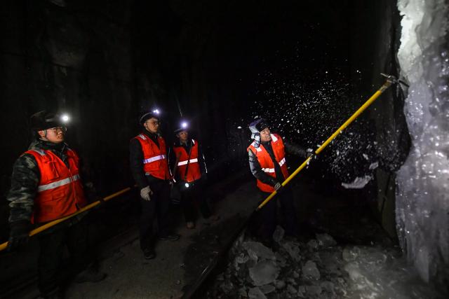 (260204) -- JINZHONG, Feb. 4, 2026 (Xinhua) -- Head of a maintenance squad (1st R) briefs about ice breaking skills in a railway tunnel in north China's Shanxi Province, Feb. 3, 2026.
  A team of maintenance technicians, most born in the 2000s, has spent the winter months shoveling and removing ice from railway tunnels deep in the mountainous terrain in Shanxi province to safeguard passengers' trips.
  Embarking on the patrol journey at dawn, they trek more than nine kilometers every day to clear ice in seven railway tunnels. The arduous chipping, shoveling and transporting of large ice chucks means the technicians are totally burned out after a day of work.
  During the Chinese New Year, the team will stay on duty to ensure the safe operation of train services. Through their efforts, thousands more who have been working far from their hometowns for almost a year will be able to ride the train and return home safe and sound. (Xinhua/Cao Yang)