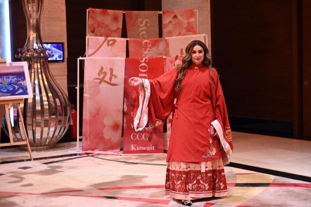 (260204) -- FARWANIYA GOVERNORATE, Feb. 4, 2026 (Xinhua) -- A Kuwaiti woman tries on traditional Chinese attire during the "Happy Chinese New Year" celebrations in Farwaniya Governorate, Kuwait, Feb. 3, 2026. (Photo by Asad/Xinhua)