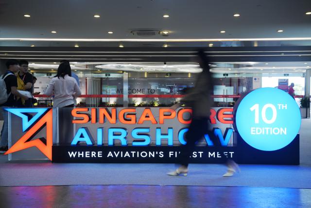 (260204) -- SINGAPORE, Feb. 4, 2026 (Xinhua) -- People walk past a signboard during the 10th Singapore Airshow at Singapore's Changi Exhibition Centre on Feb. 4, 2026. (Photo by Then Chih Wey/Xinhua)