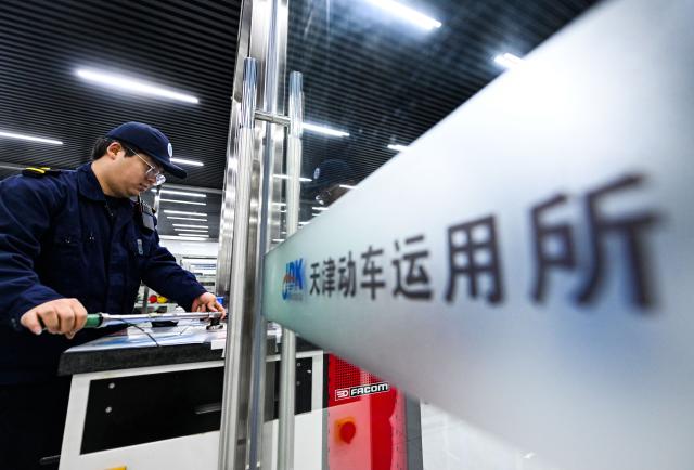 (260204) -- TIANJIN, Feb. 4, 2026 (Xinhua) -- Li Qiwei collects maintenance tools at an electric multiple unit (EMU) maintenance depot in north China's Tianjin Municipality, on Feb. 1, 2026. Several EMU trains are neatly lined up for "health checkups" inside a maintenance depot in Tianjin at the night of Feb. 1, right before the start of Spring Festival travel rush, the annual homeward journey in China, and also the world's largest human migration. 
   To ensure safe and punctual departure of these trains, Li Qiwei, the leader of a maintenance team, had to work overnight with more than 40 mates on his team to perform full-body examination for 28 sets of EMUs - a workload about 20 percent higher than that of a normal workday.
   Li has been working at the maintenance depot after he graduated with a degree in vehicle engineering from the Dalian Jiaotong University. Eight years of diligence saw him rising from green hands to a competent group leader. He said he felt very lucky to be able to contribute to the safety operation of the bullet trains, which are reuniting million of people with their families during the Spring Festival travel rush. (Xinhua/Zhao Zishuo)