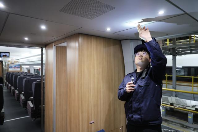 (260204) -- TIANJIN, Feb. 4, 2026 (Xinhua) -- Li Qiwei works at an electric multiple unit (EMU) maintenance depot in north China's Tianjin Municipality, on Feb. 2, 2026. Several EMU trains are neatly lined up for "health checkups" inside a maintenance depot in Tianjin at the night of Feb. 1, right before the start of Spring Festival travel rush, the annual homeward journey in China, and also the world's largest human migration. 
   To ensure safe and punctual departure of these trains, Li Qiwei, the leader of a maintenance team, had to work overnight with more than 40 mates on his team to perform full-body examination for 28 sets of EMUs - a workload about 20 percent higher than that of a normal workday.
   Li has been working at the maintenance depot after he graduated with a degree in vehicle engineering from the Dalian Jiaotong University. Eight years of diligence saw him rising from green hands to a competent group leader. He said he felt very lucky to be able to contribute to the safety operation of the bullet trains, which are reuniting million of people with their families during the Spring Festival travel rush. (Xinhua/Li Ran)