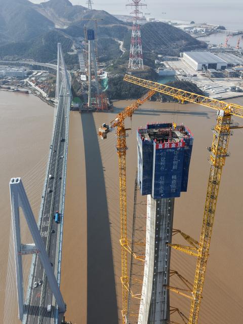 (260204) -- ZHOUSHAN, Feb. 4, 2026 (Xinhua) -- An aerial drone photo taken on Feb. 4, 2026 shows the No. 6 main tower (R, front) of the Taoyaomen highway-railway bridge under construction in Zhoushan, east China's Zhejiang Province. The No. 6 main tower of the Taoyaomen highway-railway bridge, constructed by the China Railway Major Bridge Engineering Group Co., Ltd., was topped out on Wednesday, marking a significant breakthrough of this project. (Xinhua/Huang Zongzhi)