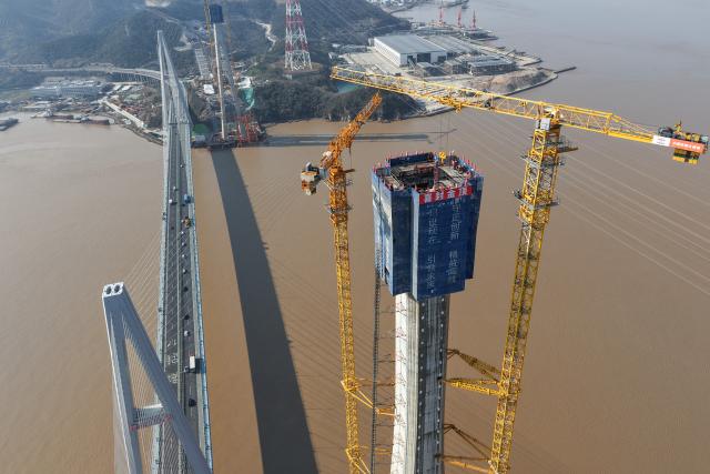 (260204) -- ZHOUSHAN, Feb. 4, 2026 (Xinhua) -- An aerial drone photo taken on Feb. 4, 2026 shows the No. 6 main tower (R, front) of the Taoyaomen highway-railway bridge under construction in Zhoushan, east China's Zhejiang Province. The No. 6 main tower of the Taoyaomen highway-railway bridge, constructed by the China Railway Major Bridge Engineering Group Co., Ltd., was topped out on Wednesday, marking a significant breakthrough of this project. (Xinhua/Huang Zongzhi)