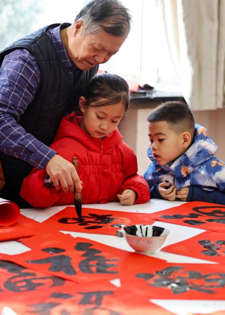 (260204) -- BEIJING, Feb. 4, 2026 (Xinhua) -- A calligraphy enthusiast teaches children to write the character "Fu", which means good fortune, on the occasion of "Lichun" in Lanzhou, northwest China's Gansu Province, on Feb. 4, 2026. Wednesday marks "Lichun," or the Beginning of Spring, the first of the 24 solar terms on the Chinese lunar calendar. (Photo by Hou Chonghui/Xinhua)