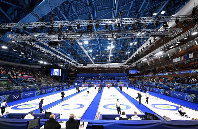 (260204) -- CORTINA D'AMPEZZO, Feb. 4, 2026 (Xinhua) -- Athletes warm up prior to the curling mixed doubles round robin session 1 match of the 2026 Milan-Cortina Winter Olympics in Cortina D'Ampezzo, Italy, Feb. 4, 2026. (Xinhua/Lian Yi)
