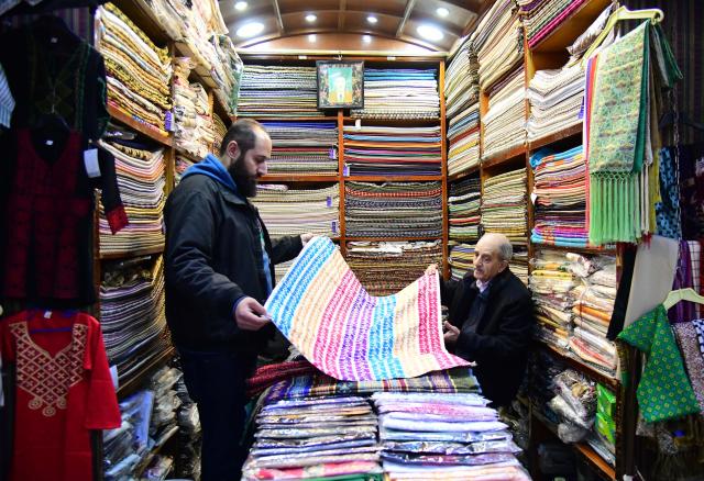 (260205) -- DAMASCUS, Feb. 5, 2026 (Xinhua) -- A man shops at a store of the Souq al-Khayyatin market in Damascus, Syria, Feb. 4, 2026. This historic market is traditionally known for tailoring, fabrics and clothing trade. (Photo by Ammar Safarjalani/Xinhua)