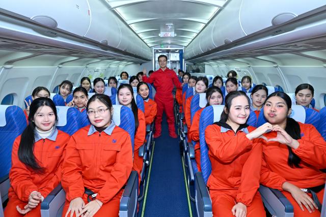 (260205) -- TIANJIN, Feb. 5, 2026 (Xinhua) -- Flight attendant trainees from Thailand, together with a Chinese teacher, pose for a group photo in a cabin simulator at the Civil Aviation University of China (CAUC) in Tianjin, north China, on Jan. 20, 2026. Yanatchara Anukun, 21, is among 28 flight attendant trainees from Thailand's Suan Dusit University (SDU), who completed a three-month study of cabin safety and management, as well as psychology of cabin service at the CAUC in Tianjin. The study is part of an aviation business exchange cooperation between CAUC and SDU. Besides that, the trainees also received practical training in a cabin simulator here to handle emergency situations in real life.  
    In October 2024, Yanatchara Anukun, as a member of SDU's teacher-student exchange group, came to China and studied for a period of time, an experience that deepened her understanding of civil aviation education and training systems of China's universities. In 2025, she once again gained the chance to China for a short-term study and training in her major. "We practiced many times in the cabin simulator to learn how to deal with the situations that may occur suddenly during flight," said Yanatchara Anukun. For her, becoming a flight attendant is not only a career choice, but also a dream. (Xinhua/Sun Fanyue)