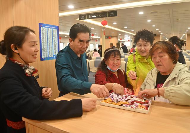 (260205) -- BEIHAI, Feb. 5, 2026 (Xinhua) -- Passengers receive candies to celebrate the maiden voyage of the Beiyou 36 passenger ship heading for Weizhou Island from Beihai in south China's Guangxi Zhuang Autonomous Region, Feb. 5, 2026. Beiyou 36, the 1,200-seat high-speed passenger ship newly put into operation in Baihai for the Spring Festival travel rush, has a total length of 71 meters, a designed speed of 29 knots, and a maximum speed of over 32 knots. (Xinhua/Lu Boan)