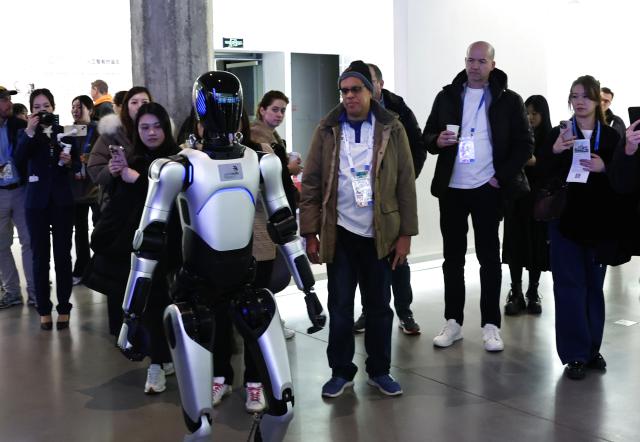 (260205) -- SHANGHAI, Feb. 5, 2026 (Xinhua) -- Guests watch a humanoid robot at an artificial intelligence temporary exhibition area at the WorldSkills Museum in Shanghai, east China, Feb. 4, 2026. As one of the 48th WorldSkills Competition Preparation Week activities, the Shanghai promotion campaign and intangible cultural heritage experience event was held here on Wednesday, which was attended by over 700 guests from home and abroad. (Xinhua/Fang Zhe)