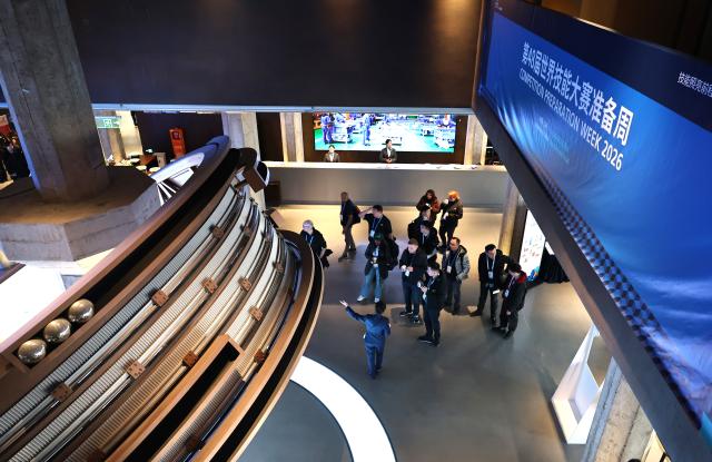 (260205) -- SHANGHAI, Feb. 5, 2026 (Xinhua) -- Guests listen to the introduction of a guide at the WorldSkills Museum in Shanghai, east China, Feb. 4, 2026. As one of the 48th WorldSkills Competition Preparation Week activities, the Shanghai promotion campaign and intangible cultural heritage experience event was held here on Wednesday, which was attended by over 700 guests from home and abroad. (Xinhua/Fang Zhe)