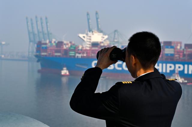 (260205) -- TIANJIN, Feb. 5, 2026 (Xinhua) -- Xu Qinping checks the navigation channel through a telescope on a cargo ferry at Tianjin Port in Tianjin, north China, Feb. 4, 2026.
  Sun Bo and Xu Qinping are both port pilots at Tianjin Port. A port pilot needs to be familiar not only with the port's navigation conditions, but also with vessel maneuvering skills. Working around the clock across navigation channels, berthing locations and anchorage grounds, they are responsible for the safe arrival and departure of ships at the port. 
  "When guiding the anchoring of a vessel weighing hundreds of thousands of tons, we must maneuver with centimeter-level precision," said Sun Bo. According to him, the most dangerous part is embarking from the anchorage, when a pilot must choose the right moment to climb up a soft ladder. A single moment of carelessness could lead to a fall into the sea. Moreover, port pilots work year-round without breaks, with the daily ship schedule dictating their routine. 
  Over his 22-year career, Sun Bo has piloted more than 4,500 vessels and also witnessed the rapid development of China's ports and foreign trade. (Xinhua/Zhao Zishuo)