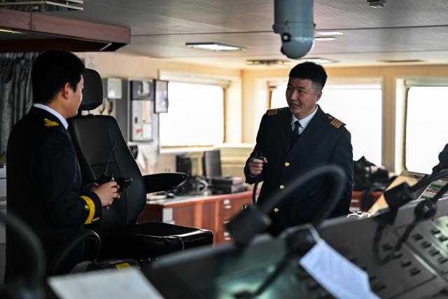 (260205) -- TIANJIN, Feb. 5, 2026 (Xinhua) -- Sun Bo (R) communicates with a captain on a cargo ferry at Tianjin Port in Tianjin, north China, Feb. 4, 2026.
  Sun Bo and Xu Qinping are both port pilots at Tianjin Port. A port pilot needs to be familiar not only with the port's navigation conditions, but also with vessel maneuvering skills. Working around the clock across navigation channels, berthing locations and anchorage grounds, they are responsible for the safe arrival and departure of ships at the port. 
  "When guiding the anchoring of a vessel weighing hundreds of thousands of tons, we must maneuver with centimeter-level precision," said Sun Bo. According to him, the most dangerous part is embarking from the anchorage, when a pilot must choose the right moment to climb up a soft ladder. A single moment of carelessness could lead to a fall into the sea. Moreover, port pilots work year-round without breaks, with the daily ship schedule dictating their routine. 
  Over his 22-year career, Sun Bo has piloted more than 4,500 vessels and also witnessed the rapid development of China's ports and foreign trade. (Xinhua/Zhao Zishuo)