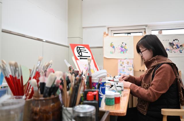 (260205) -- TIANJIN, Feb. 5, 2026 (Xinhua) -- A painter mixes colors for New Year paintings at Tianjin Yangliuqing Fine Arts Press in Tianjin, north China, Feb. 4, 2026. In celebration of the upcoming Year of the Horse, Tianjin Yangliuqing Fine Arts Press released a series of horse-themed New Year paintings, integrating traditional New Year painting skills with modern design. (Xinhua/Sun Fanyue)