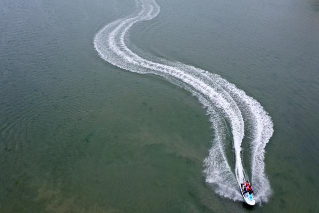 (260205) -- BEIHAI, Feb. 5, 2026 (Xinhua) -- An aerial drone photo taken on Feb. 5, 2026 shows tourists enjoying water activities in the sea near Beihai City, south China's Guangxi Zhuang Autonomous Region. (Xinhua/Lu Boan)