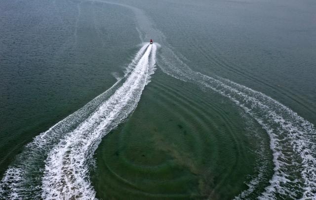 (260205) -- BEIHAI, Feb. 5, 2026 (Xinhua) -- An aerial drone photo taken on Feb. 5, 2026 shows tourists enjoying water activities in the sea near Beihai City, south China's Guangxi Zhuang Autonomous Region. (Xinhua/Lu Boan)