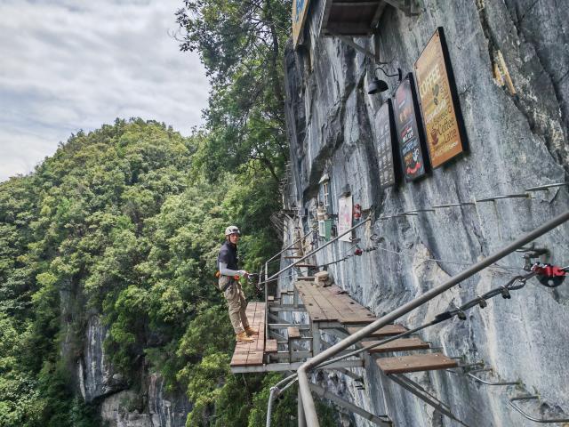 (260205) -- GUIYANG, Feb. 5, 2026 (Xinhua) -- A coach performs via ferrata climb at a cliff café in Libo County, southwest China's Guizhou Province, July 11, 2024. TO GO WITH "Across China: Novel coffee experiences brew new, elevated tourism trends in SW China" (Xinhua/Wu Si)