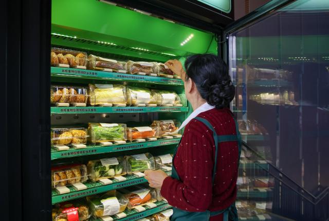 (260205) -- SHENZHEN, Feb. 5, 2026 (Xinhua) -- A staff member arranges packaged vegetables in a food bank terminal at Yitian Village of Futian District in Shenzhen, south China's Guangdong Province, Dec. 19, 2025. TO GO WITH "Feature: Low-key experiment changing how food aid works in south China's Shenzhen" (Xinhua/Liang Xu)