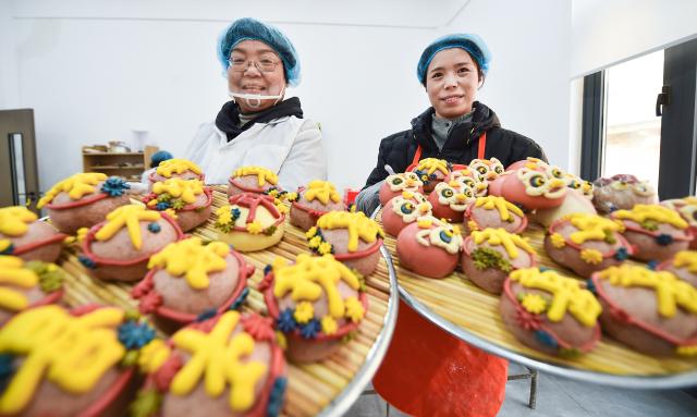 (260205) -- BEIJING, Feb. 5, 2026 (Xinhua) -- Workers display artistic steamed buns for sale in Luoyang City, central China's Henan Province, Feb. 4, 2026. Fairs and events are held across the country, where people shop for goods in preparation for the upcoming Spring Festival, or the Chinese New Year. (Photo by Huang Zhengwei/Xinhua)