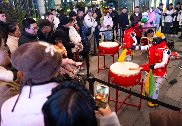 (260205) -- WUHAN, Feb. 5, 2026 (Xinhua) -- People watch humanoid robot performance at an event themed on the "Hubei New Spring International Consumption Season" in Wuhan, central China's Hubei Province, Feb. 5, 2026. The "Hubei New Spring International Consumption Season" kicked off here on Thursday, attempting to create diverse consumption scenarios for the upcoming Spring Festival. (Xinhua/Xiao Yijiu)