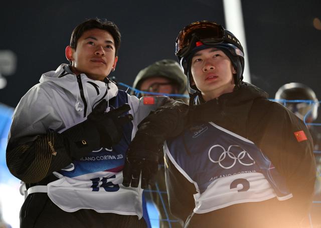 (260205) -- LIVIGNO, Feb. 5, 2026 (Xinhua) -- Su Yiming (R) and Ge Chunyu of China react during the Snowboard Men's Big Air qualification of the Milan-Cortina 2026 Olympic Winter Games in Livigno, Italy, Feb. 5, 2026. (Xinhua/Xia Yifang)