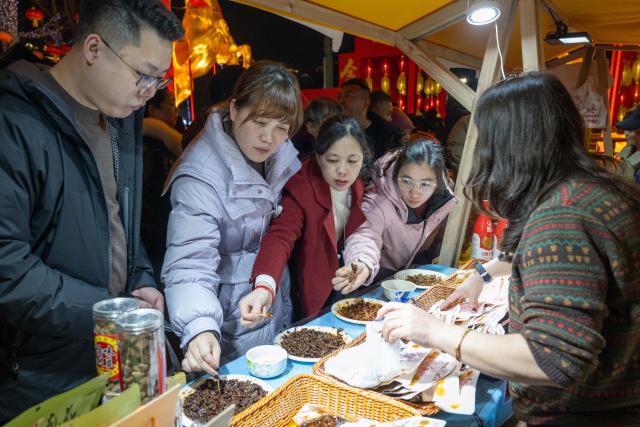 (260206) -- CHONGQING, Feb. 6, 2026 (Xinhua) -- People shop at a fair featuring Chinese New Year goods in southwest China's Chongqing Municipality, Feb. 5, 2026. A fair featuring Chinese New Year goods kicked off here on Thursday, offering residents a one-stop destination for New Year shopping with diverse choices. (Xinhua/Chen Cheng)