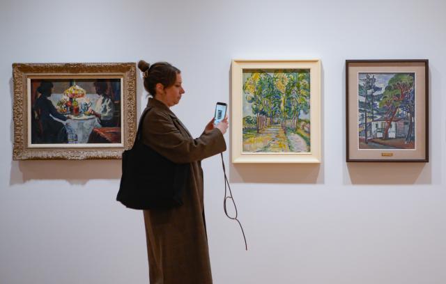 (260206) -- VANCOUVER, Feb. 6, 2026 (Xinhua) -- A woman takes photos of paintings at a preview of the exhibition "That Green Ideal: Emily Carr and the Idea of Nature" at the Vancouver Art Gallery in Vancouver, British Columbia, Canada, on Feb. 5, 2026. (Photo by Liang Sen/Xinhua)