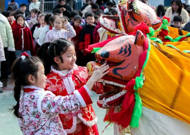 (260206) -- BEIJING, Feb. 6, 2026 (Xinhua) -- Children interact with a "tiger" during a performance at a primary school in Bo'ai County, Jiaozuo City of central China's Henan Province, Feb. 5, 2026. With the Spring Festival drawing near, various festive events are held across the country to celebrate the Chinese New Year. (Photo by Cheng Quan/Xinhua)