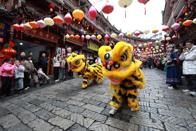 (260206) -- BEIJING, Feb. 6, 2026 (Xinhua) -- People watch a lion dance as a celebration for a wedding of Buyi ethnic group in Duyun City, southwest China's Guizhou Province, Feb. 5, 2026. With the Spring Festival drawing near, various festive events are held across the country to celebrate the Chinese New Year. (Photo by Xiao Wei/Xinhua)