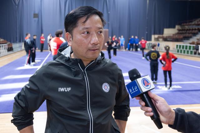 (260206) -- BUDAPEST, Feb. 6, 2026 (Xinhua) -- Rong Jun, a member of the IWUF Technical Committee and director of the European federation's technical committee, is interviewed during the European Wushu Taolu training camp in Budapest, Hungary, on Feb. 5, 2026. TO GO WITH "Europe launches first high-level wushu taolu camp ahead of Youth Olympics" (Photo by Attila Volgyi/Xinhua)